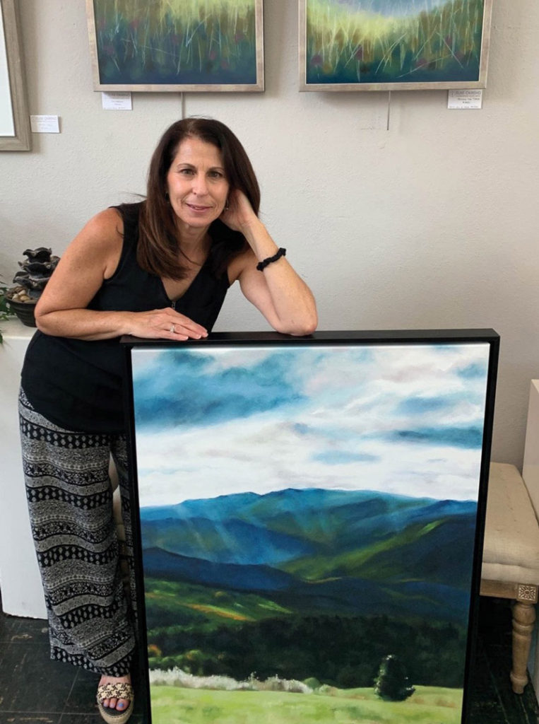 Elise Okrend stands with one of her completed watercolor paintings